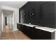 Hallway boasts custom black cabinets, a marble countertop, and sleek metal wine racks against a modern black wall at 7014 E Palo Verde Ln, Paradise Valley, AZ 85253