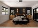 Bedroom with a wood accent wall, hardwood floors, stylish furniture, and a window overlooking the outdoors at 7014 E Palo Verde Ln, Paradise Valley, AZ 85253