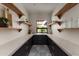 Walk-in pantry featuring open shelving and a black cabinet base topped with a bright countertop, and light patterned tile floor at 7014 E Palo Verde Ln, Paradise Valley, AZ 85253