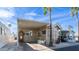 Charming home featuring covered parking, a cozy seating area, and lush palm trees against a bright blue sky at 834/837 S Beryl/Aquamarine Dr, Apache Junction, AZ 85119