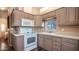 Well-lit kitchen features mauve cabinets, laminate countertops, white appliances and a large single basin sink at 834/837 S Beryl/Aquamarine Dr, Apache Junction, AZ 85119