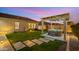 Beautiful backyard features a hot tub with pergola cover, lush green grass and stone paver pathways at 10455 E Thatcher Ave, Mesa, AZ 85212
