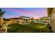 Expansive backyard featuring a lush lawn, outdoor kitchen, spa, and desert landscaping at 10455 E Thatcher Ave, Mesa, AZ 85212