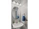 Half-bathroom featuring a stylish pedestal sink, oval mirror, and elegant fixtures at 10455 E Thatcher Ave, Mesa, AZ 85212
