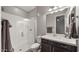 Modern bathroom showcasing a sleek walk-in shower and a dark vanity with a white countertop at 10455 E Thatcher Ave, Mesa, AZ 85212