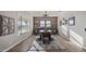 Bright dining room featuring a modern light fixture, wood accent wall, and natural light from large windows at 10455 E Thatcher Ave, Mesa, AZ 85212