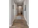 Hallway with wood flooring, neutral walls, and decorative accents leading to various rooms in the home at 10455 E Thatcher Ave, Mesa, AZ 85212