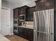 A close up of the kitchen's built in oven and microwave, with stainless steel refrigerator and dark cabinetry at 10455 E Thatcher Ave, Mesa, AZ 85212