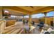 Inviting covered patio with a built-in grill, bar area, TV, and lounge seating with a view of the sparkling pool at 10455 E Thatcher Ave, Mesa, AZ 85212