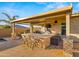 Charming outdoor kitchen area with bar seating and covered patio, perfect for hosting and enjoying outdoor meals at 10455 E Thatcher Ave, Mesa, AZ 85212