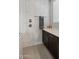 Close up of the shower with grey textured tile and silver hardware in a bright bathroom at 10455 E Thatcher Ave, Mesa, AZ 85212