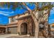 Charming two-story home showcasing a stone archway entrance, a well-kept yard, and a mature tree at 11130 E Shepperd Ave, Mesa, AZ 85212