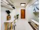 Hallway featuring white tile flooring, modern decor, and a decorative wooden door at 11737 N 143Rd Dr, Surprise, AZ 85379