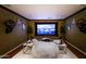 Inviting home theater with a large screen, comfortable seating, and ambient lighting for an immersive viewing experience at 11737 N 143Rd Dr, Surprise, AZ 85379