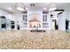 A spacious kitchen featuring a large island with granite countertops, stainless steel appliances, and elegant lighting at 11737 N 143Rd Dr, Surprise, AZ 85379