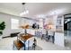 Bright kitchen with large island, seating, wooden table and modern lighting fixtures at 11737 N 143Rd Dr, Surprise, AZ 85379