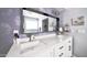 Stylish bathroom vanity with double sinks, and elegant lighting, complemented by decorative wallpaper at 1207 E Alice Ave, Phoenix, AZ 85020