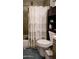 Functional bathroom featuring a shower-tub combo, toilet, and stylish dark wood shelving at 1207 E Alice Ave, Phoenix, AZ 85020