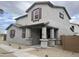 Two-story home featuring a covered porch with brick supports and decorative shutters at 14650 W Sand Hills Rd, Surprise, AZ 85387