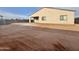A view of the home's back exterior showing the covered patio and the large, unfinished backyard at 1586 N Himosa Dr, Casa Grande, AZ 85122
