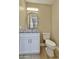 Powder room with stylish vanity, granite countertop, modern fixtures, arched mirror, and a white toilet at 1586 N Himosa Dr, Casa Grande, AZ 85122
