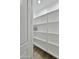 Walk-in pantry features bright lighting, white shelving for organized storage, and neutral toned flooring at 1586 N Himosa Dr, Casa Grande, AZ 85122