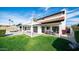 Expansive backyard featuring a covered patio, lush green lawn, and beautiful architectural details of the home at 17414 N 56Th Way, Scottsdale, AZ 85254
