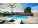 Sparkling pool surrounded by lush landscaping, comfortable lounge chairs, and an umbrella for shade at 17414 N 56Th Way, Scottsdale, AZ 85254