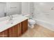 Bathroom featuring wood-look vanity and a shower-tub combo at 17649 W Young St, Surprise, AZ 85388