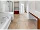 Bathroom featuring tile floors, dual sinks, a soaking tub, and a walk-in shower at 17649 W Young St, Surprise, AZ 85388