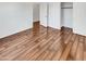 Bright bedroom with wood-look flooring, open closet and white door at 17649 W Young St, Surprise, AZ 85388