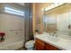Well-lit bathroom featuring a tub with shower and decorative marble countertop with vanity at 18215 N Shadow Ct, Surprise, AZ 85374
