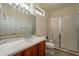 Bathroom featuring a tiled shower with a glass door, single sink vanity with marble countertop at 18215 N Shadow Ct, Surprise, AZ 85374