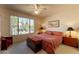 A cozy bedroom includes a ceiling fan and a window with views of the desert landscape at 18215 N Shadow Ct, Surprise, AZ 85374