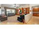 Spacious living room featuring a ceiling fan, wood floors, built-in bookshelves, and backyard views at 18215 N Shadow Ct, Surprise, AZ 85374
