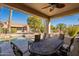 Comfortable covered patio with view of sparkling pool, desert landscaping and blue skies at 18215 N Shadow Ct, Surprise, AZ 85374