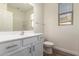 Bathroom featuring white cabinets, modern fixtures, a toilet, and natural light at 21198 W Berkeley Rd, Buckeye, AZ 85396