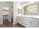 Bright bathroom featuring double vanity sinks, white cabinets, and a framed mirror at 21198 W Berkeley Rd, Buckeye, AZ 85396