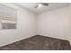 A carpeted bedroom with a window and ceiling fan at 21198 W Berkeley Rd, Buckeye, AZ 85396