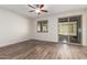 Bright bedroom features a ceiling fan, wood-style flooring, and a sliding glass door leading to an outdoor space at 21198 W Berkeley Rd, Buckeye, AZ 85396