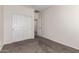 A carpeted room with a double door closet and an open doorway to the hallway at 21198 W Berkeley Rd, Buckeye, AZ 85396