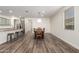 Open concept dining area featuring sleek wood floors, a modern light fixture, and a view into the kitchen at 21198 W Berkeley Rd, Buckeye, AZ 85396