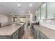 Well-equipped kitchen with stainless steel appliances, granite countertops, a large island, and light green cabinetry at 21198 W Berkeley Rd, Buckeye, AZ 85396