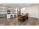 Open kitchen and dining area featuring wood floors, light green cabinetry, granite countertops, and stainless steel appliances at 21198 W Berkeley Rd, Buckeye, AZ 85396