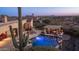 Aerial view of backyard pool, outdoor kitchen, desert landscape, and surrounding community at 2330 N Channing --, Mesa, AZ 85207