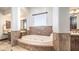 Bright bathroom featuring a soaking tub with stone surround and a vanity with dark wood cabinets at 2330 N Channing --, Mesa, AZ 85207