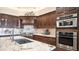 Gourmet kitchen boasts custom cabinetry, stainless steel appliances, granite countertops, double ovens, and tile backsplash at 2330 N Channing --, Mesa, AZ 85207