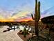 Gorgeous backyard featuring a pool with rock detail, mature Saguaro cactus and stunning Arizona sunset at 2330 N Channing --, Mesa, AZ 85207