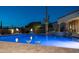 Two martinis sit poolside at this lit backyard pool with rock waterfall features and lush desert landscaping at 2330 N Channing --, Mesa, AZ 85207