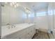 Bathroom featuring white cabinetry, double sinks, a large mirror, and a combined tub and shower at 3128 E Cheryl Dr, Phoenix, AZ 85028
